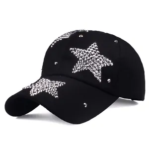 Detailed close-up of silver rhinestones and metal studs on a black cotton baseball cap