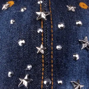 Macro detail of denim baseball cap with silver stars and rhinestones on fabric