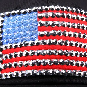 Macro shot of American flag embroidery and sparkling silver rhinestones on a black cap