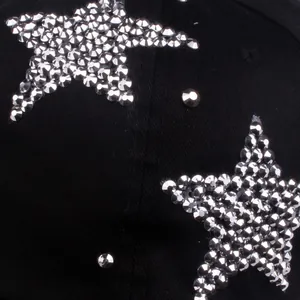 Detailed macro shot of silver rhinestone star patterns on black cotton baseball cap fabric