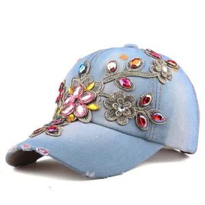 Detailed view of light blue denim baseball cap with floral embroidery and colorful rhinestones