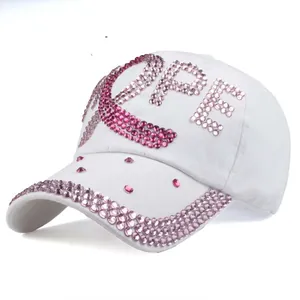 Detail van de HOPE-belettering en lintembleem van roze strassteentjes op witte baseballpet