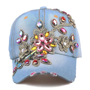 Close-up of light blue denim baseball cap with floral embroidery and colorful rhinestones