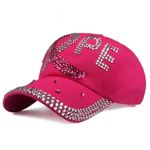 Detail van roze honkbalpet met HOPE-tekst en roze lintontwerp met glanzende steentjes