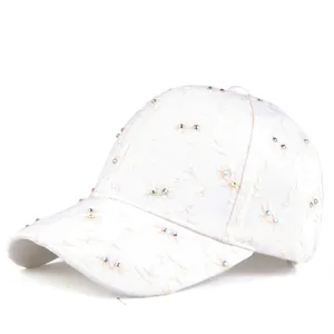 White baseball cap with floral embroidery and rhinestones for women on white background
