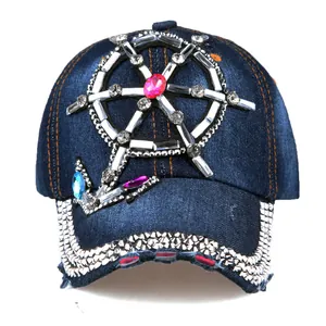 Detailed view of rhinestones steering wheel and anchor pattern on blue denim baseball cap