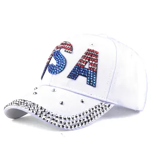 Detail of USA rhinestone logo and silver metal studs on a white denim baseball cap