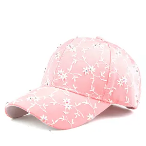 Detail of pink baseball cap with white floral embroidery and rhinestone embellishments