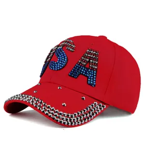 Detail view of red baseball cap with USA rhinestone design and silver studs on brim