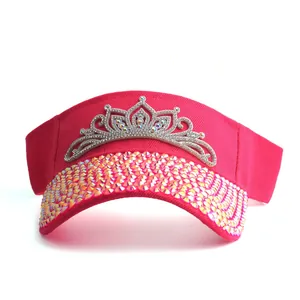 Detail showing crystal tiara ornament and rhinestones on the pink sun visor hat