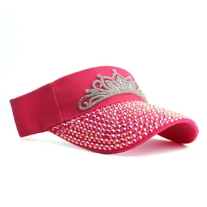 Close-up of bright pink sun visor with sparkling rhinestones and a silver tiara crown