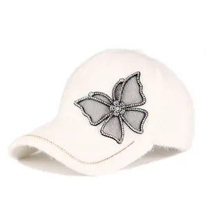 Detailopname van de vlinder-strass applicatie op een crèmekleurige pluche pet