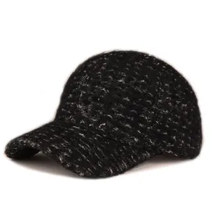 Close-up of black fuzzy knit texture on warm winter baseball cap with curved brim