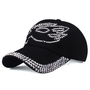 Detailed view of black suede baseball cap with shimmering silver rhinestone wing pattern