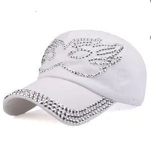 Close-up of white cotton baseball cap featuring intricate silver rhinestone bird pattern