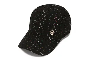 Detail von schwarzer Tweed-Textur und bunten Pailletten auf Cap mit rundem Metall-Logo