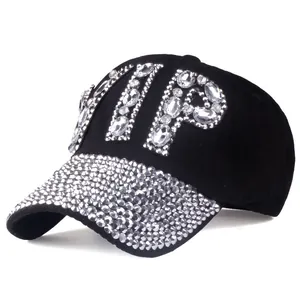Detail of a black baseball cap featuring large VIP rhinestone letters and a studded brim