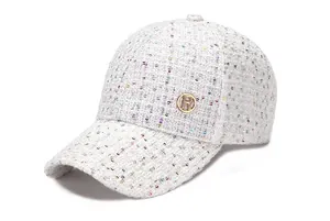 Detailansicht der weißen Tweed-Baseballkappe mit Pailletten und goldenem B-Buchstaben-Emblem