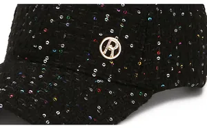 Nahaufnahme der schwarzen Tweed-Baseballkappe mit bunten Pailletten und goldener R-Schnalle
