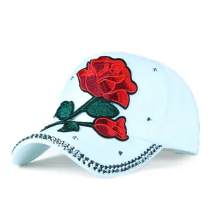 Detail of rose embroidery and sparkling rhinestones on light blue baseball cap