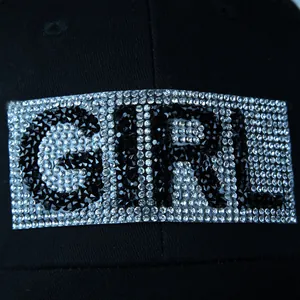 Close-up of sparkling GIRL rhinestone lettering on black cotton baseball cap