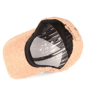 Detail of the warm peach baseball cap showing black inner lining and fuzzy fleece texture