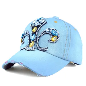 Close-up of light blue denim baseball cap with rhinestone fleur-de-lis and distressed brim