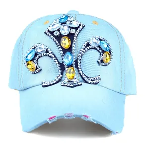 Close-up of rhinestone fleur-de-lis pattern on light blue denim baseball cap with distressed brim