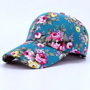 Detailed view of floral baseball cap with rose patterns on teal canvas fabric