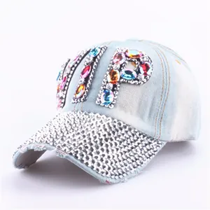 Detailed view of hand-set rhinestones and VIP crystal lettering on blue denim cap