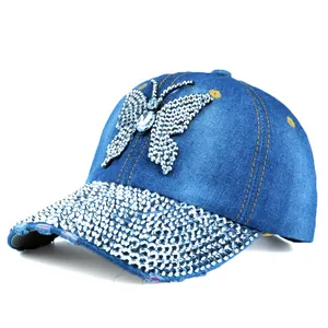 Detailed close-up of butterfly rhinestone design and crystals on navy denim baseball cap