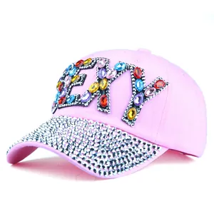 Detailed view of colorful acrylic rhinestones forming SEXY letters on pink baseball cap