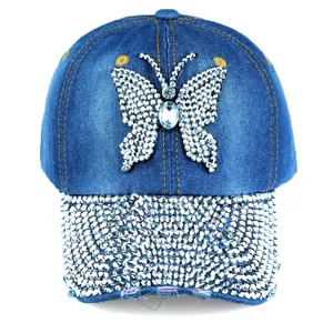 Detail of blue denim baseball cap featuring rhinestone butterfly and shimmering visor