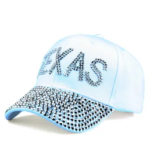 Detail of the glittering silver TEXAS rhinestone letters on a light blue baseball cap