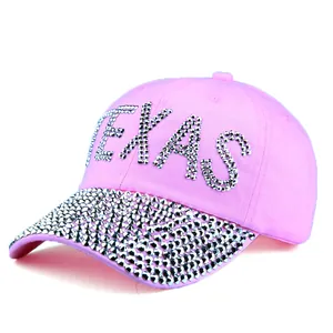 Close-up of pink baseball cap featuring sparkling TEXAS rhinestones and studded brim detail