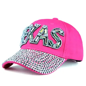 Detail einer glitzernden rosaroten Baseballkappe mit TEXAS-Schriftzug aus Strasssteinen