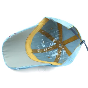 Detail of light blue distressed denim baseball cap with inner yellow edge binding