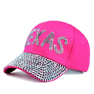 Detailed close-up of Texas rhinestone lettering and sparkling gems on pink baseball cap