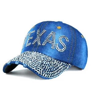 Detailed view of the rhinestone TEXAS logo and sparkling brim on blue denim cap