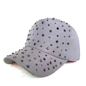 Close-up of textured grey baseball cap featuring shimmering black rhinestone embellishments