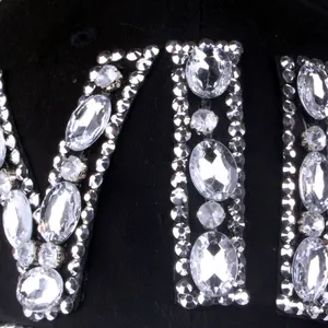 Macro shot of sparkling crystal rhinestones and VIP lettering on black denim cap