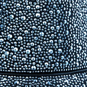 Détail macro de strass argentés étincelants sur un chapeau bob en tissu noir chic