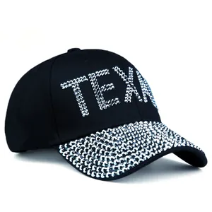 Close-up of shimmering TEXAS rhinestone lettering and studded brim on black baseball cap