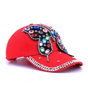 Détail macro d'une casquette rouge avec papillon en strass colorés fait à la main