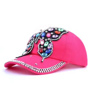Détail de la casquette rose avec papillon en strass colorés et cristaux argentés