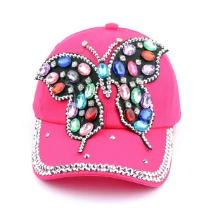 Détail macro du papillon en strass coloré fait main sur casquette en coton magenta