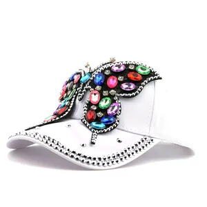 Détail de papillon en pierres colorées et strass sur une casquette de baseball blanche