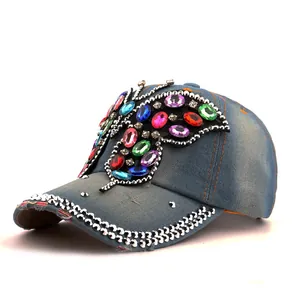 Détails de papillon en strass colorés et denim vieilli sur une casquette de baseball