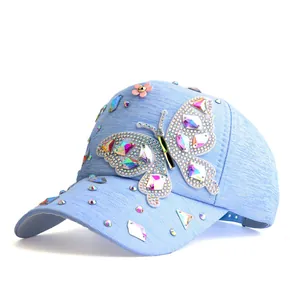 Gros plan détaillé d'une casquette bleu clair avec strass arc-en-ciel et motif papillon