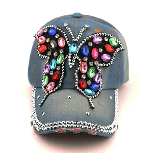 Détail macro du papillon en strass sur une casquette de baseball en jean bleu
